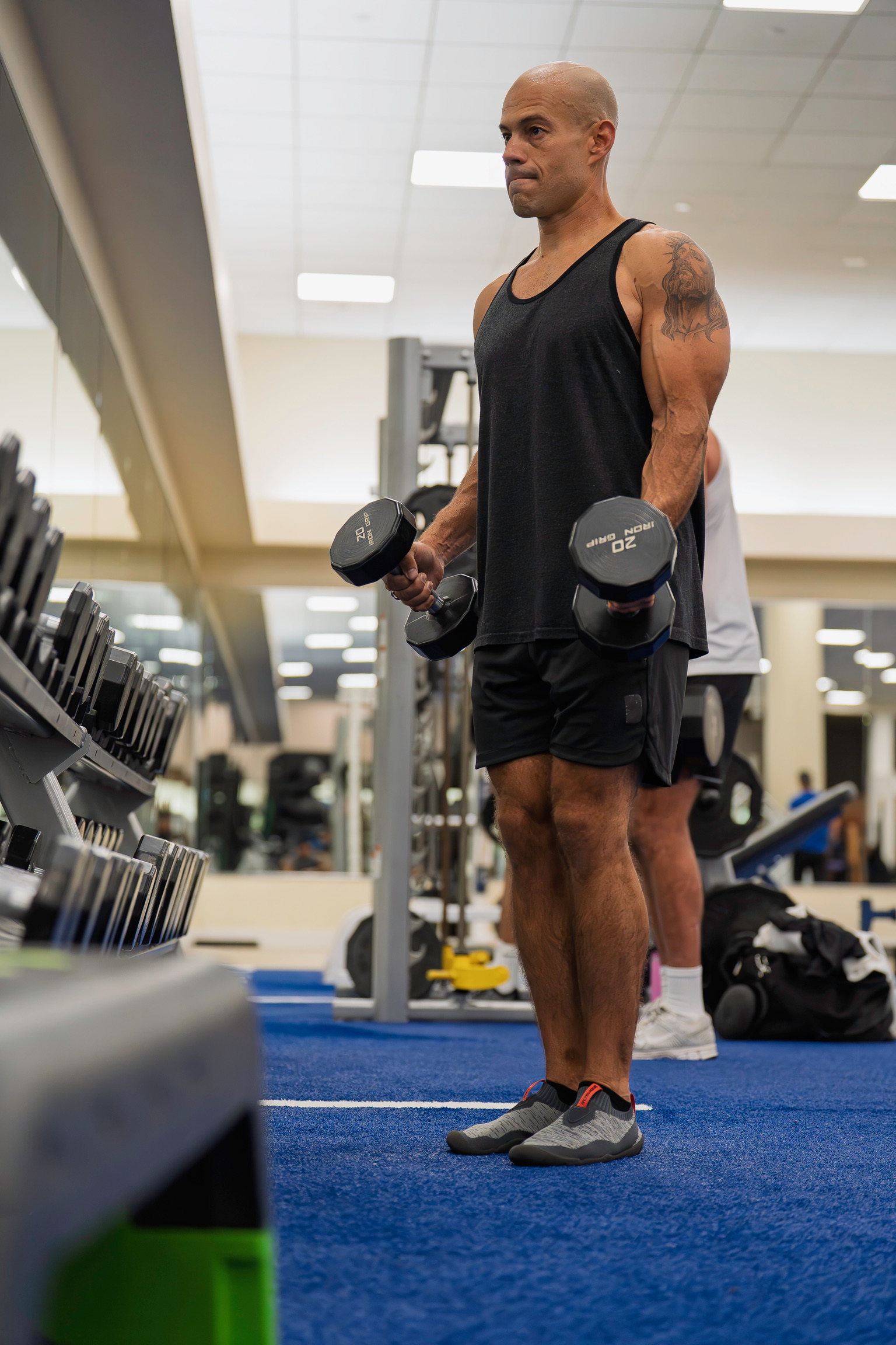 Luiz Guimaraes standing in a gym holding two dumbbells